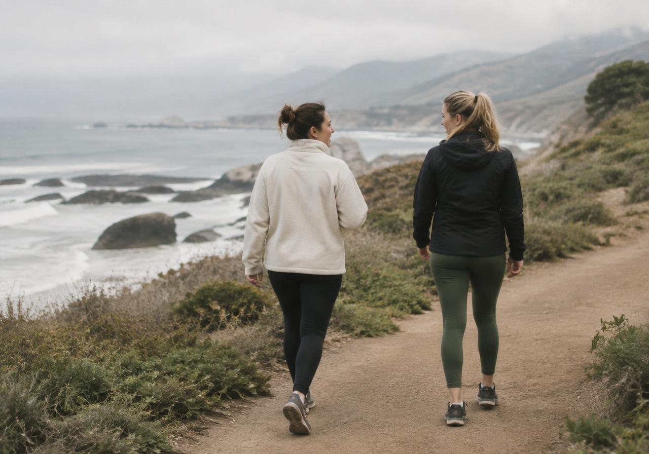 Two women talking on a coastal walking trail